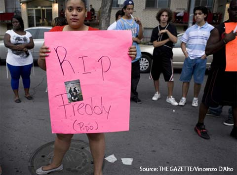 Montreal Riot - Woman holds up RIP sign for Fredy Villanueva, shot by police.